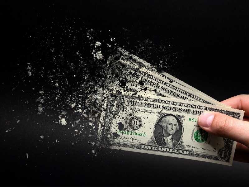 billetes desintegrándose con un fondo negro