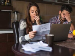 pareja haciendo cuentas debido a deudas en tarjetas de crédito 